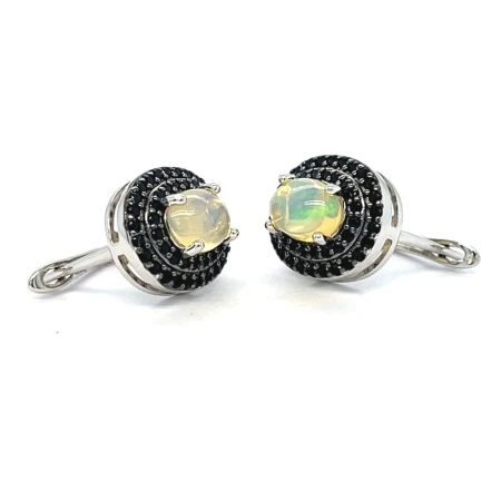 Srebrne rodowane kolczyki próby 925 z naturalnym opalem etiopskim oraz czarnym spinelem, ozdobione elegancką okrągłą oprawą.
