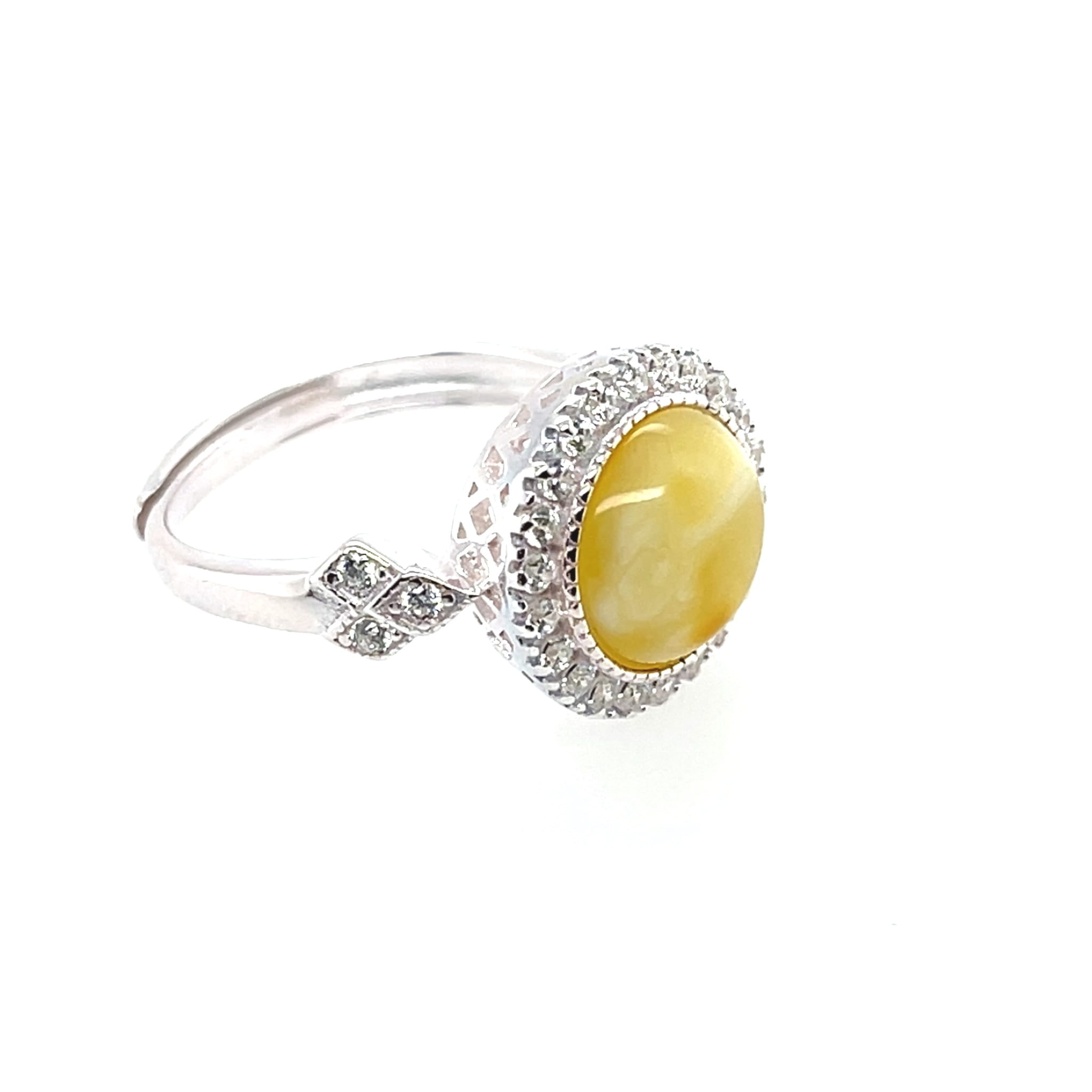 Elegancki pierścionek z okrągłym oczkiem  z bursztynem mleczno - miodowym, białymi cyrkoniami w srebrze 925.